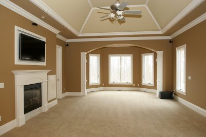 16-Master bedroom suite with fireplace, vaulted ceiling, and sitting area beyond.
