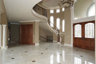2-Curved open stairway with wrought iron balustrade by Finelli Architectural Ironworks under a custom-built dome by Builder. Marble tile floor with painted woodwork and stained Cherry 8' doors.