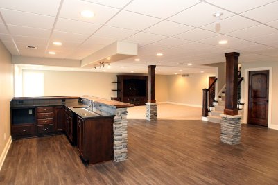 15-Lower Level Recreation Room and bar with stone & wood columns over Luxury Vinyl Tile Flooring