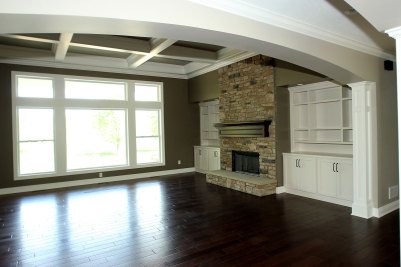 5-Central gallery with view into Great Room featuring stone fireplace and custom built cabinetry.